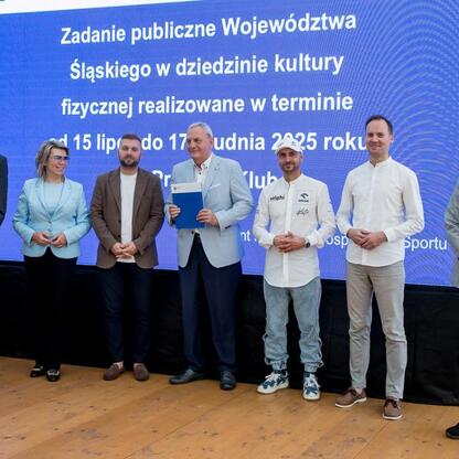 Wicemarszałek Leszek Pietraszek i przedstawiciele klubów sportowych podczas symbolicznych prezentacji czeków na Superauto.pl Stadionie Śląskim. (wygenerowano przez AI)