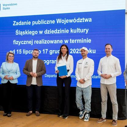 Wicemarszałek Leszek Pietraszek i lokalni politycy uczestniczą w ceremonii wręczenia symbolicznych czeków na Superauto.pl Stadionie Śląskim. (wygenerowano przez AI)