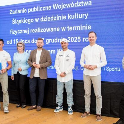 Grupa przedstawicieli Silesia na uroczystości wręczenia symbolicznych czeków na Superauto.pl Stadionie Śląskim. (wygenerowano przez AI)