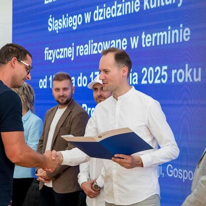 Wicemarszałek Leszek Pietraszek i przedstawiciele klubów sportowych podczas symbolicznych prezentacji czeków na Superauto.pl Stadionie Śląskim. (wygenerowano przez AI)