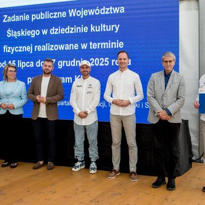 Grupa osób przedstawiających program wspierania klubów sportowych w Superauto.pl Stadion Śląskim. (wygenerowano przez AI)