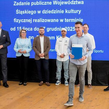 Wicemarszałek Leszek Pietraszek i przedstawiciele klubów sportowych podczas symbolicznych prezentacji czeków na Superauto.pl Stadionie Śląskim. (wygenerowano przez AI)