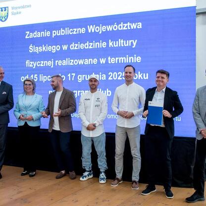 Wicemarszałek Leszek Pietraszek wręcza symboliczne czeki przedstawicielom klubów sportowych na Superauto.pl Stadionie Śląskim. (wygenerowano przez AI)