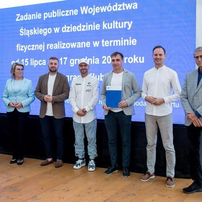 Wicemarszałek Leszek Pietraszek i przedstawiciele Silesia Sejmiku podczas symbolicznych prezentacji czeków dla 154 klubów sportowych w Superauto.pl Stadionie Śląskim. (wygenerowano przez AI)