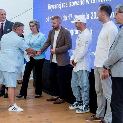 Wicemarszałek Leszek Pietraszek i przedstawiciele klubów sportowych podczas symbolicznych prezentacji czeków na Superauto.pl Stadionie Śląskim. (wygenerowano przez AI)