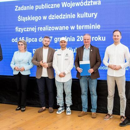 Wicemarszałek Leszek Pietraszek wręcza symboliczne czeki przedstawicielom klubów sportowych w ramach Programu Klub w Superauto.pl Stadionie Śląskim. (wygenerowano przez AI)