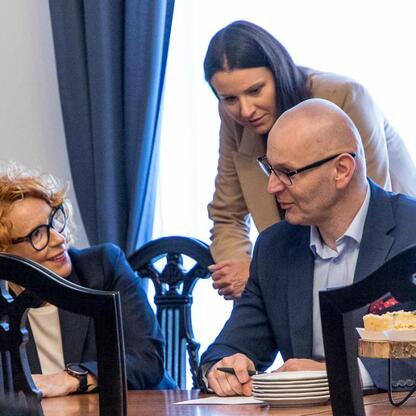 Grupa ludzi w strojach formalnych dyskutuje w konferencji na Śląsku, skupiającej się na bezpieczeństwie energetycznym i przemysłowym. (wygenerowano przez AI)