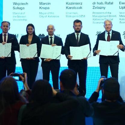 Grupa siedmiu kluczowych postaci z Kongresu Nowej Mobilności w Katowicach, podpisanie listu intencyjnego o współpracy w tworzeniu Centrum Nowej Mobilności. (wygenerowano przez AI)