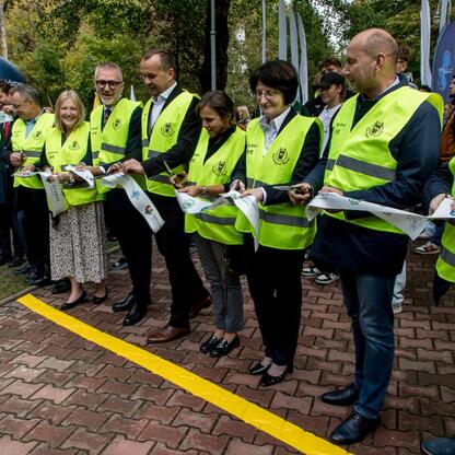 Ceremonia odsłonięcia figurki Geodezjusza w Parku Kościuszki, z udziałem oficjalnych osób. (wygenerowano przez AI)