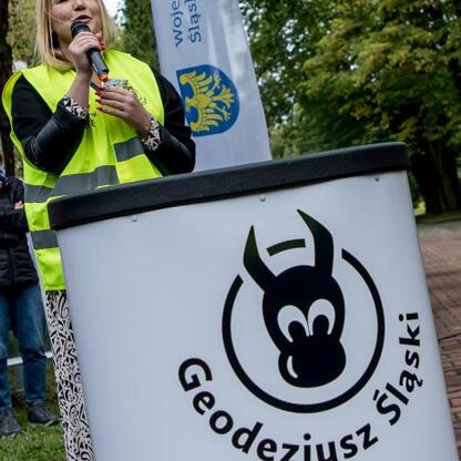 Joanna Bojczuk, członkini Zarządu Województwa Śląskiego, przemawia na podium Geodezjusza Śląskiego. (wygenerowano przez AI)