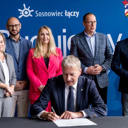 Podpis: Wojciech Saługa, Marszałek Województwa Śląskiego, podpisuje umowę na rewitalizację byłej kopalni KWK Kazimierz-Juliusz w Sosnowcu. (wygenerowano przez AI)