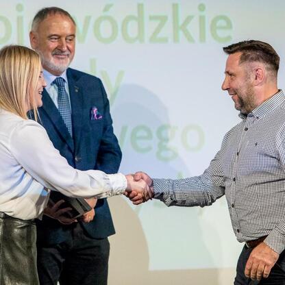 Na zdjęciu przedstawiono moment z Wojewódzkich Obchodów Światowego Dnia Turystyki, gdzie osoby wyróżnione za zasługi dla rozwoju turystyki w regionie otrzymują dyplomy Marszałka Województwa Śląskiego. (wygenerowano przez AI)