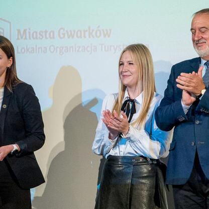 Na Wojewódzkich Obchodach Światowego Dnia Turystyki wojewódzka kadra nagrodziła osoby za zasługi w rozwoju turystyki w regionie. Uroczystość zakończyła się wręczeniem dyplomów i klapsami. (wygenerowano przez AI)