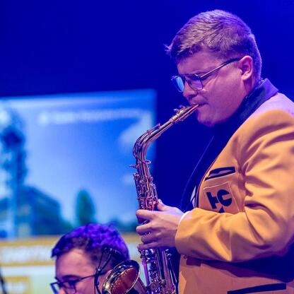 Silesia: Celebratory event in Tarnowskie Góry, Poland, honoring tourism development. Saxophonist performs on stage during Wojewódzkie Obchody Światowego Dnia Turystyki. (wygenerowano przez AI)