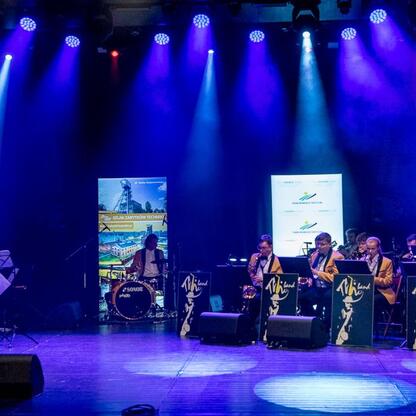 Wojewódzkie Obchody Światowego Dnia Turystyki w Tarnowskich Górach. Koncert TG Big Band podświetla festiwalowy klimat. (wygenerowano przez AI)
