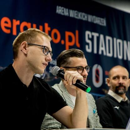 Zdjęcie przedstawia moment z konferencji prasowej 17. edycji Silesia Marathon, która odbędzie się na Superauto.pl Stadion Śląski. Uczestnicy omawiają organizację wydarzenia. (wygenerowano przez AI)