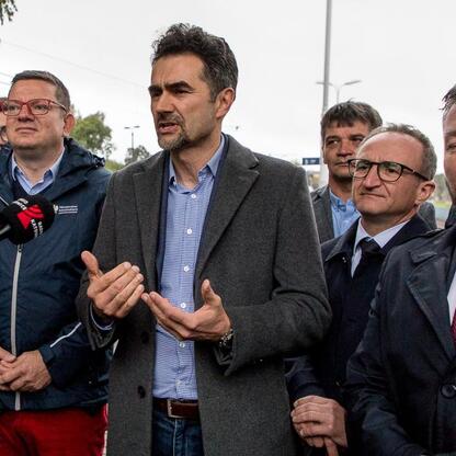 Grzegorz Boski, wicemarszałek Województwa Śląskiego, przemawia na konferencji prasowej dotyczącej nowych połączeń kolejowych Bielsko-Biała - Kraków. (wygenerowano przez AI)