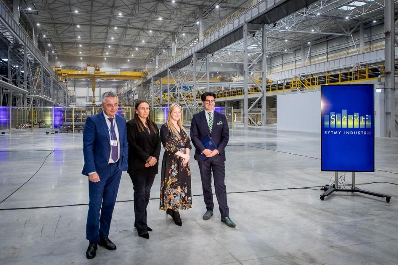 Grupa czterech osób w hali Cognor Mill w Siemianowicach Śląskich, związana z projektem "Śląskie. W rytmie industrii". (wygenerowano przez AI)