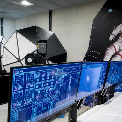 Space-themed exhibit at Planetarium Śląskiego, featuring a detailed model of a space telescope and futuristic displays. (wygenerowano przez AI)