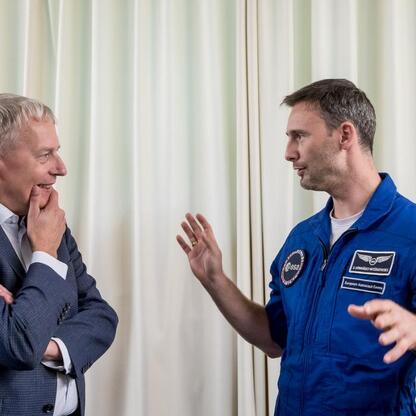 Wojciech Saługa i Sławosz Uznański-Wiśniewski w rozmowie na konferencji prasowej w Planetarium Śląskim. (wygenerowano przez AI)