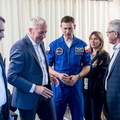 Grupa naukowców i astronautów w spotkaniu w Planetarium Śląskim. (wygenerowano przez AI)