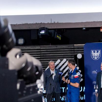 Wojciech Saługa, Marszałek Województwa Śląskiego, wraz z astronautą Sławoszem Uznańskim-Wiśniewskim i lokalnymi władzami podczas konferencji prasowej w Planetarium Śląskim. (wygenerowano przez AI)