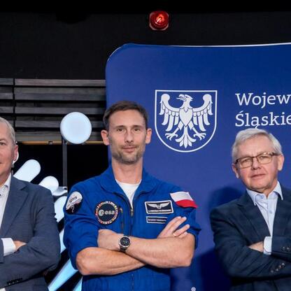 Astronauta w niebieskim garniturze z ESA logo, otoczony przez oficjalne osoby Śląskiego Voivodztwa. (wygenerowano przez AI)
