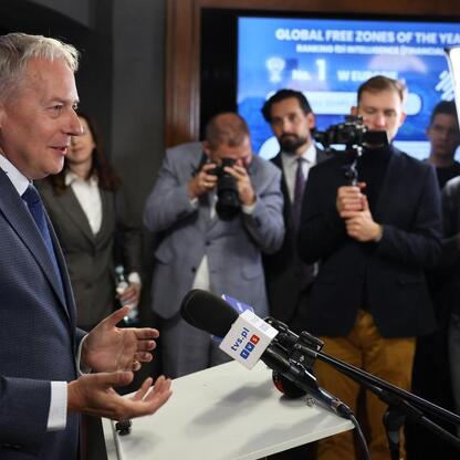 Marszałek Wojciech Saługa przemawia na podium podczas konferencji prasowej, podkreślając sukces Katowickiej Specjalnej Strefy Ekonomicznej w konkursie Financial Times. (wygenerowano przez AI)