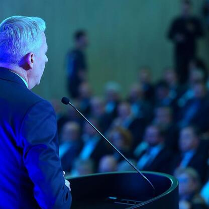 Mężczyzna w garniturze przemawia na podium, omawiając przyszłość regionu Śląska w kontekście transformacji energetycznej. (wygenerowano przez AI)