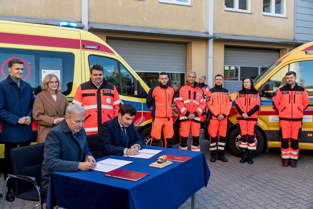 Marszałek Wojciech Saługa, wraz z dyrektorami i marszałkiem województwa, podpisuje umowę na nowe ambulansy dla Wojewódzkiego i Rejonowego Pogotowia Ratunkowego. (wygenerowano przez AI)