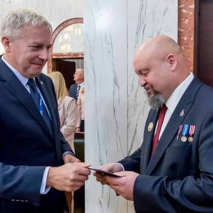 Wojciech Saługa, Marszałek Województwa Śląskiego, wręcza Grzegorzowi Kamińskiemu Złotą Honorową Odznakę za Zasługi dla Województwa Śląskiego. (wygenerowano przez AI)