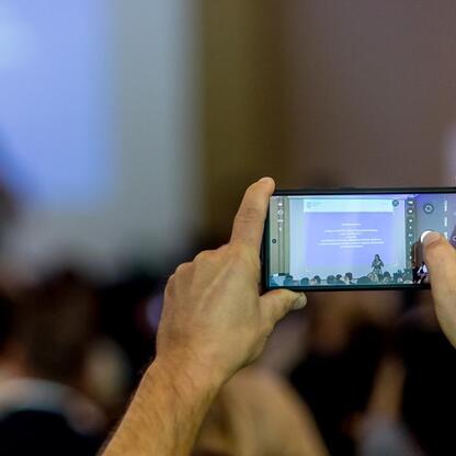 Konferencja o poprawie jakości powietrza w Śląsku, uczestnicy zapisują prezentacje na smartfony. (wygenerowano przez AI)