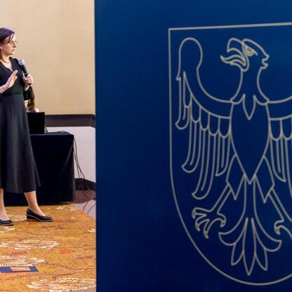 Podczas konferencji o poprawie jakości powietrza w Silesia, uczestniczka prezentuje strategie redukcji emisji zanieczyszczeń. (wygenerowano przez AI)