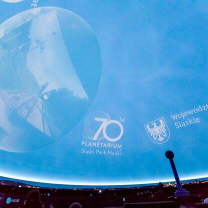 Wśród 280 słuchaczy w planetarium Śląskiego Parku Nauki oglądają spektakl kosmiczny. (wygenerowano przez AI)