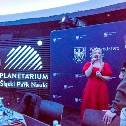 Joanna Bojczuk, członek zarządu Województwa Śląskiego, prowadzi rozmowę podczas transmisji z Planetarium Śląskiego. (wygenerowano przez AI)