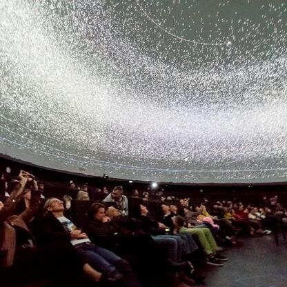 Wśród 280 słuchaczy w Planetarium Śląskiego podczas 208. notowania listy piosenek Radio 357, widoczna jest fascynująca projekcja kosmiczna. (wygenerowano przez AI)