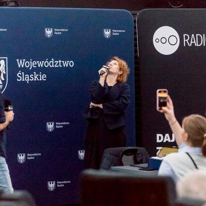 Widoczna jest scena z koncertu Radio 357 w Planetarium Śląskim, z widownią i mikrofonami. (wygenerowano przez AI)