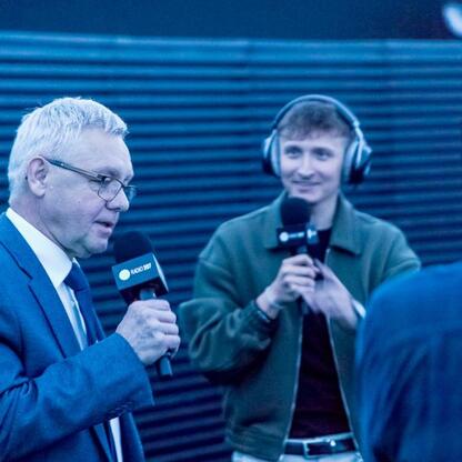 Ludzie rozmawiają w studiu Radio 357 w Planetarium Śląskim, podkreślając muzykę i naukę. (wygenerowano przez AI)