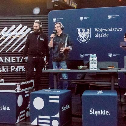 Live broadcast from Planetarium Śląskiego, Radio 357 event, four presenters with microphones, cosmic theme, Silesian colors. (wygenerowano przez AI)