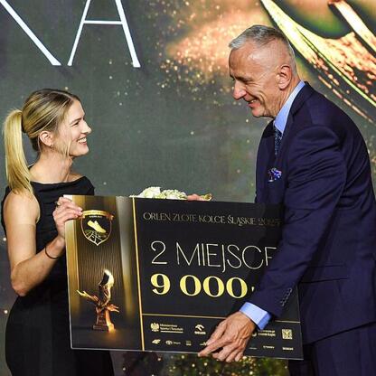 Wicemarszałek Leszek Pietraszek wręcza nagrodę najlepszym polskim lekkoatletom Maria Żodzik i Maksymilianowi Szwedowi na Superauto.pl Stadionie Śląskim. (wygenerowano przez AI)