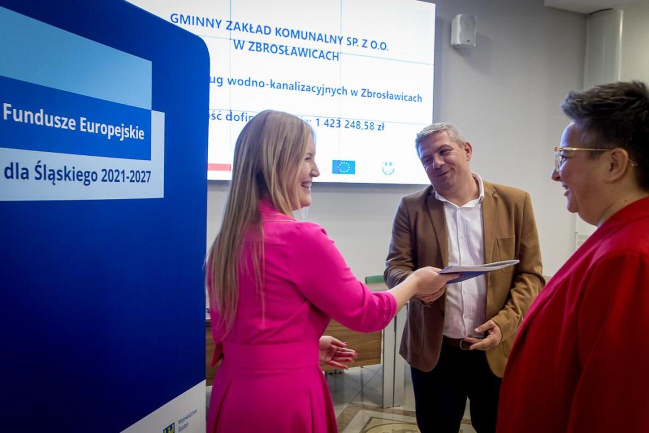Grzegorz Boski i Marcin Ryś wicemarszałkowie Województwa Śląskiego wręczają listy gratulacyjne przedstawicielom beneficjentów projektów dofinansowanych ze środków europejskich. (wygenerowano przez AI)