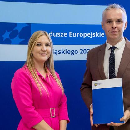 Joanna Bojczuk i inżynier Marcin Ryś przedstawiają projekt dofinansowany z Europejskich Funduszy dla Śląska 2021-2027. (wygenerowano przez AI)