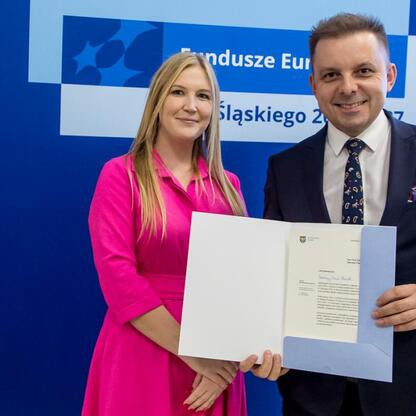 Joanna Bojczuk i Grzegorz Boski wręczają certyfikaty projektom bénéficjentów z Funduszy Europejskich dla Śląska 2021-2027. (wygenerowano przez AI)