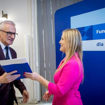 Joanna Bojczuk i Grzegorz Boski wręczają listy gratulacyjne za sukcesy projektów finansowanych ze środków europejskich dla Śląska. (wygenerowano przez AI)