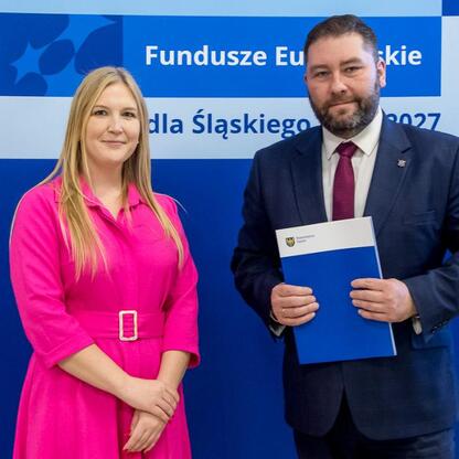 Joanna Bojczuk i inżynier Marcin Ryś przedstawiają projekty dofinansowane z Europejskich Funduszy dla Śląska 2021-2027. (wygenerowano przez AI)