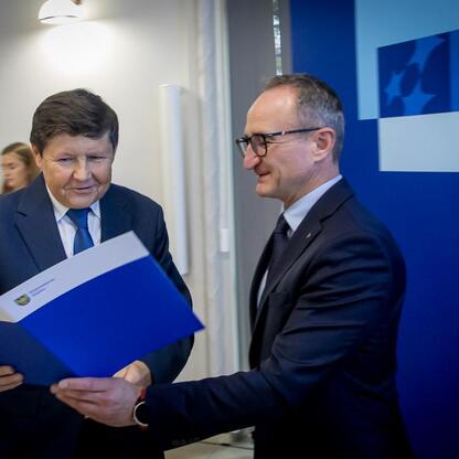 Grzegorz Boski, wicemarszałek Województwa Śląskiego, wręcza dokumenty przedstawicielowi zarządu w kontekście funduszy europejskich dla Śląska. (wygenerowano przez AI)