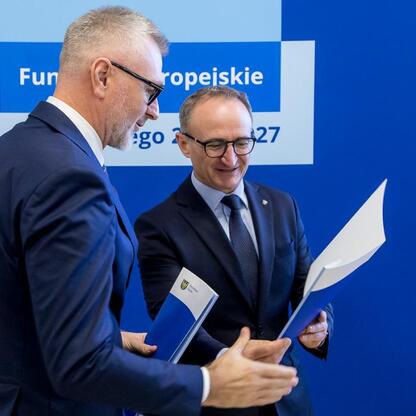 Grzegorz Boski i Marcin Ryś wicemarszałkowie województwa śląskiego wręczają dokumenty przedstawicielom beneficjentów projektów europejskich. (wygenerowano przez AI)