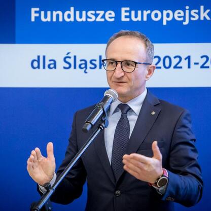 Wicemarszałek Grzegorz Boski przemawia na podium o funduszach europejskich dla Śląska 2021-2027. (wygenerowano przez AI)