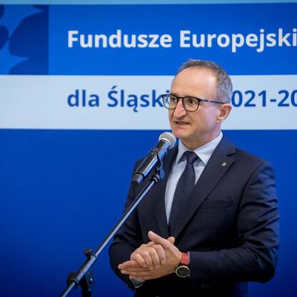 Wicemarszałek Grzegorz Boski przemawia na podium podczas konferencji o Europejskich Fundach dla Śląska 2021-2027. (wygenerowano przez AI)