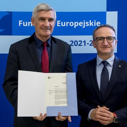 Grzegorz Boski i Marcin Ryś wręczają listy gratulacyjne za projekty dofinansowane z Europejskich Funduszy 2021-2027. (wygenerowano przez AI)